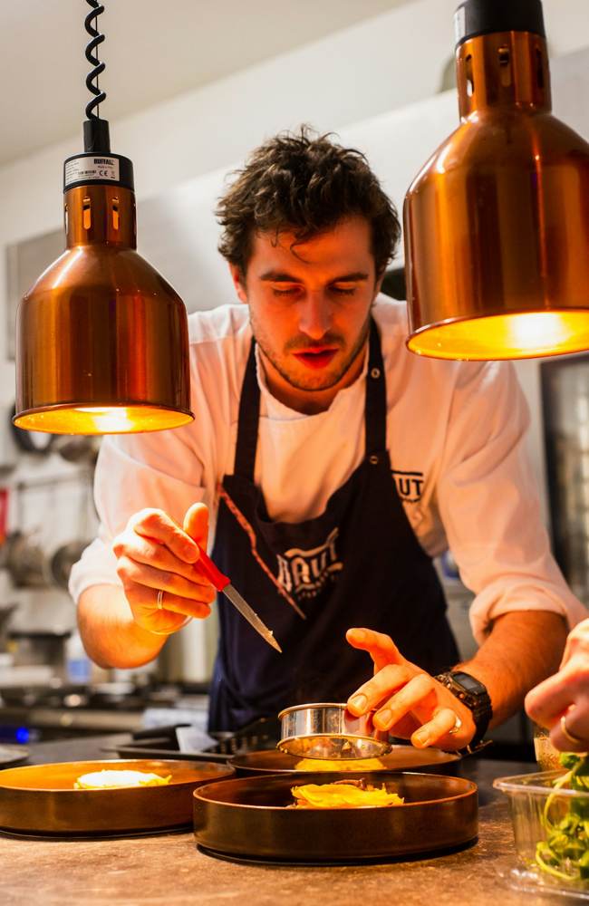 A chef plating food in a kitchen