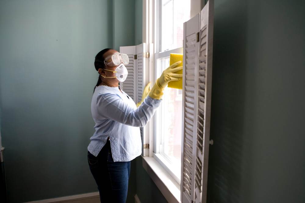 A housekeeper cleaning a window